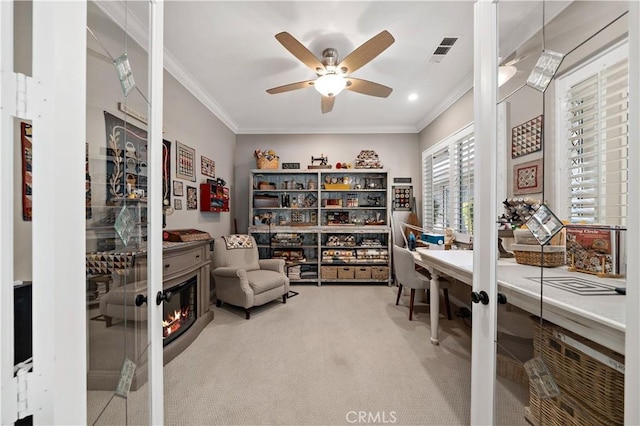 carpeted home office featuring ceiling fan, ornamental molding, and visible vents