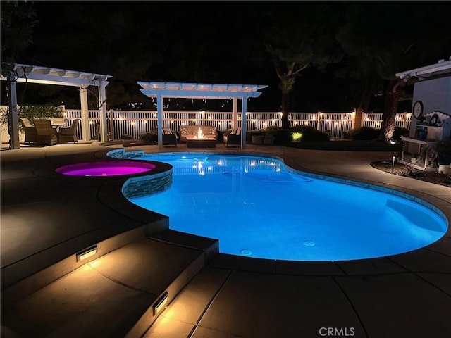 pool at night with a pool with connected hot tub, fence, a pergola, and a patio