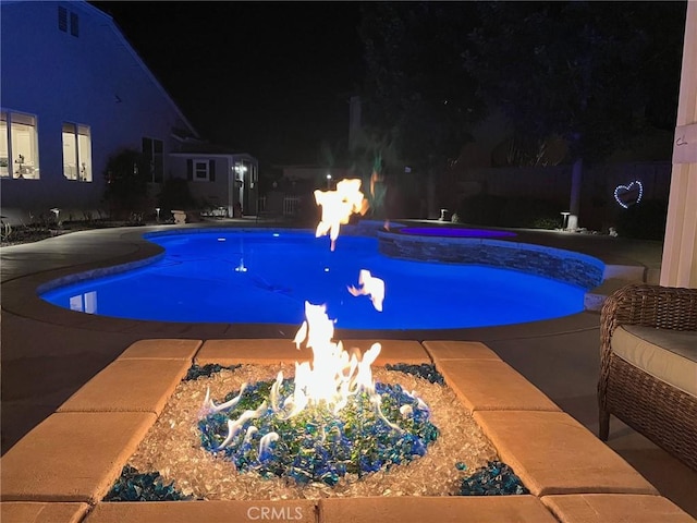 pool at twilight with a fire pit and a fenced in pool