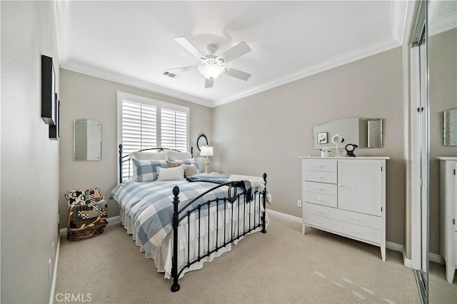 bedroom featuring ceiling fan, light colored carpet, visible vents, baseboards, and crown molding