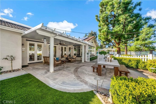 view of patio with a ceiling fan, outdoor dining space, french doors, and fence