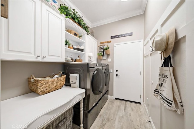 laundry area with washer and dryer, cabinet space, crown molding, and light wood finished floors