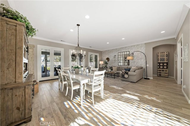 dining space with a chandelier, light wood-style flooring, recessed lighting, baseboards, and crown molding