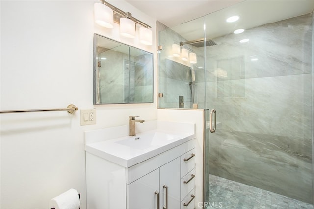 full bathroom featuring a marble finish shower, visible vents, and vanity