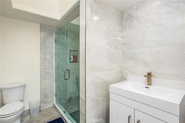 full bath featuring a stall shower, tile walls, vanity, and toilet