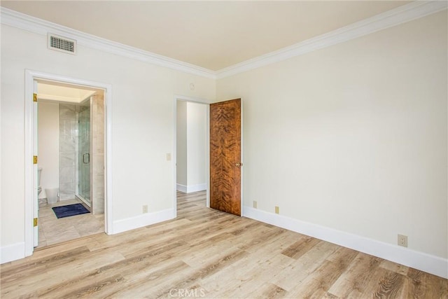 spare room featuring visible vents, crown molding, baseboards, and wood finished floors