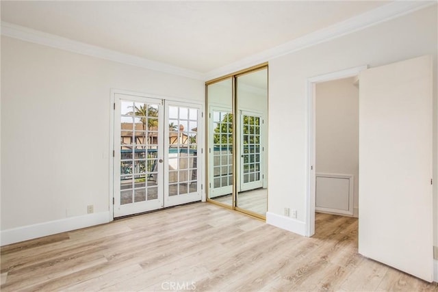 unfurnished room with baseboards, crown molding, and wood finished floors