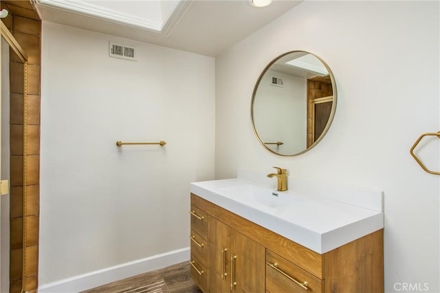 bathroom featuring wood finished floors, vanity, visible vents, and baseboards