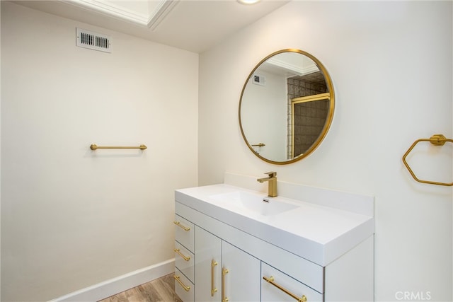 bathroom with baseboards, visible vents, wood finished floors, and vanity