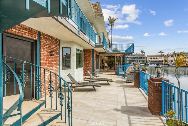 view of patio featuring a water view and a balcony