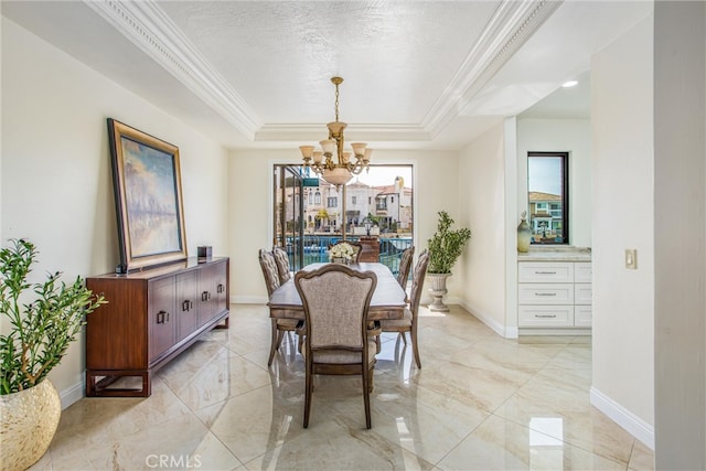 dining space featuring a textured ceiling, a notable chandelier, a raised ceiling, and crown molding