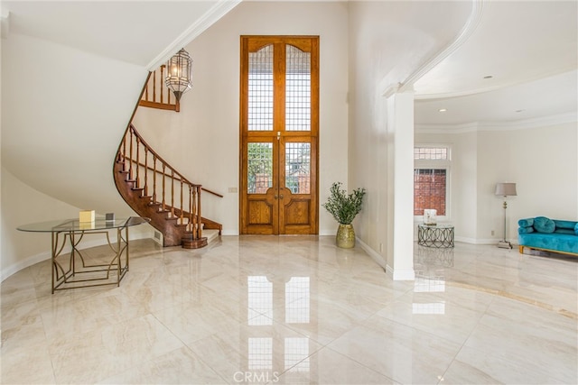 entryway with marble finish floor, a wealth of natural light, and crown molding