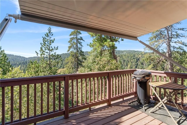 wooden terrace featuring a wooded view