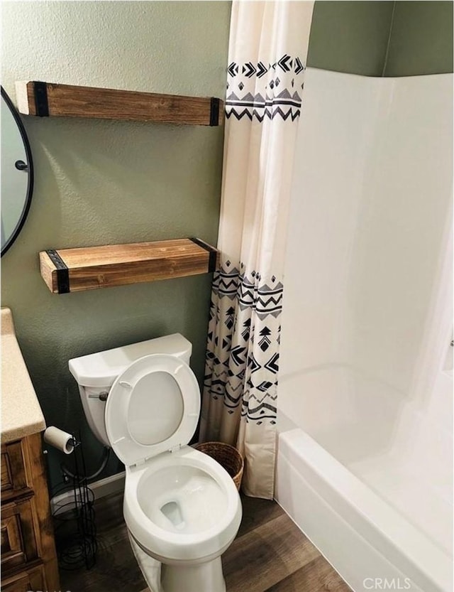 full bath featuring a textured wall, vanity, wood finished floors, and toilet