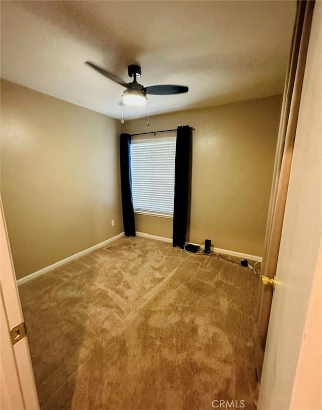 unfurnished room with ceiling fan, carpet flooring, and baseboards