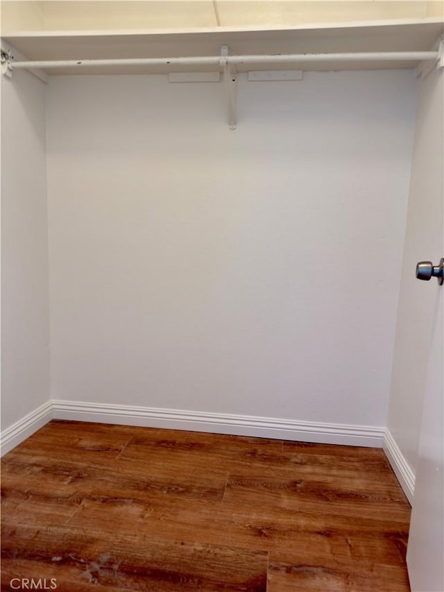 walk in closet with wood finished floors