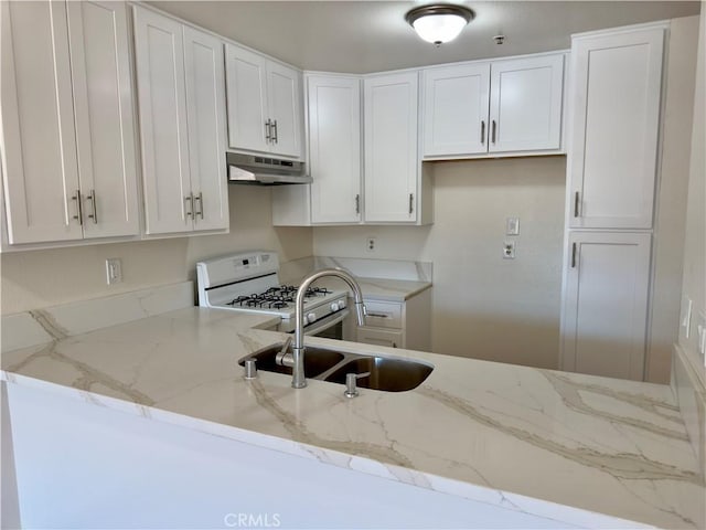 kitchen featuring white cabinets, white gas range, light stone countertops, and under cabinet range hood