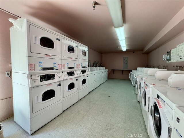 community laundry room with light floors, stacked washing maching and dryer, and washer and dryer