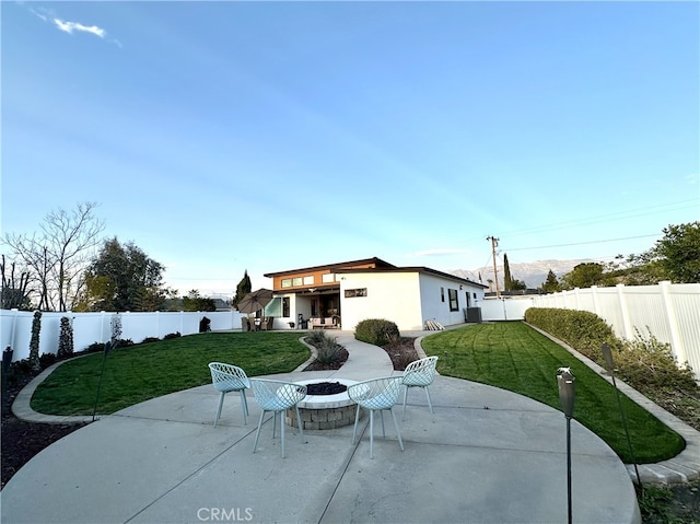 rear view of house featuring a yard, a fenced backyard, and a patio