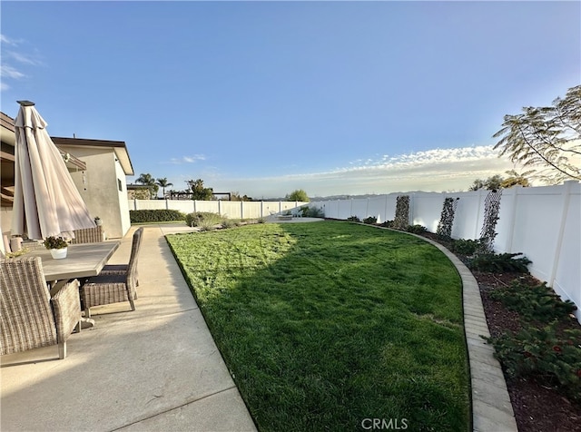 view of yard with a patio, outdoor dining area, and a fenced backyard