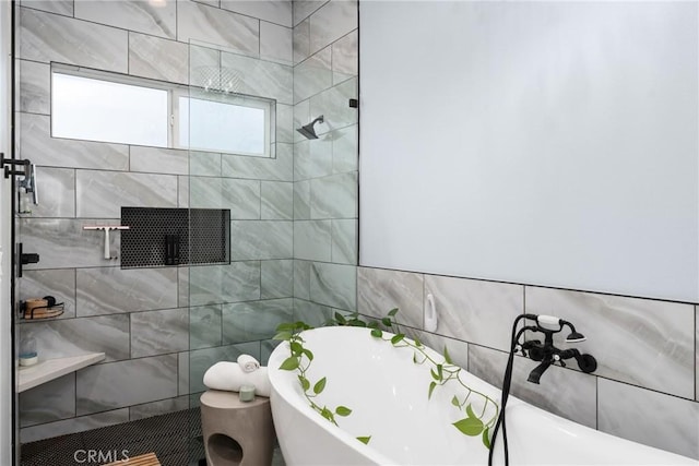 full bathroom featuring a freestanding tub, a tile shower, and tile walls