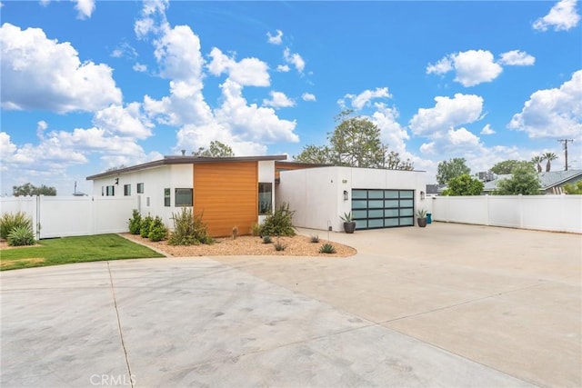 exterior space featuring fence, stucco siding, concrete driveway, and a garage