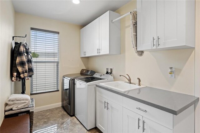 clothes washing area featuring cabinet space, a sink, baseboards, separate washer and dryer, and recessed lighting