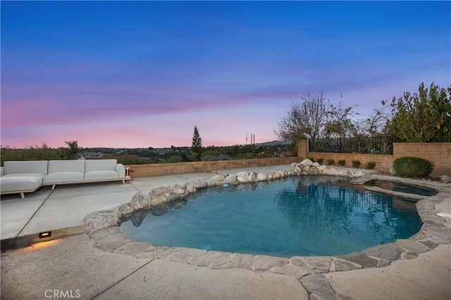 pool at dusk with an outdoor hangout area, a patio area, fence, and a fenced in pool