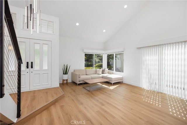 unfurnished living room with baseboards, high vaulted ceiling, wood finished floors, and recessed lighting