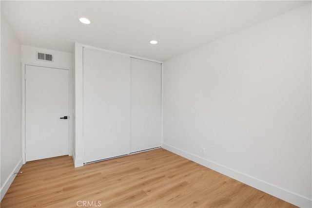 unfurnished bedroom with light wood-style floors, recessed lighting, a closet, and visible vents