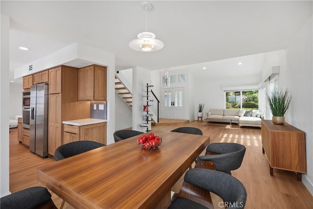 dining room with light wood-style floors, stairs, and recessed lighting