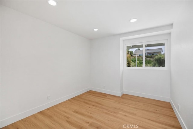 unfurnished room with recessed lighting, light wood-style flooring, and baseboards