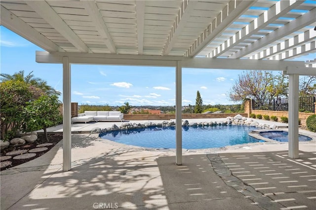 view of pool with a patio area, fence, and a pool with connected hot tub