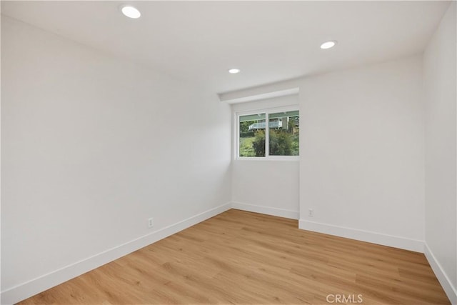 spare room with recessed lighting, light wood-style flooring, and baseboards