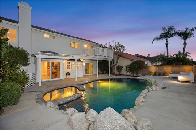 view of swimming pool featuring a patio area, fence, a fenced in pool, and an in ground hot tub