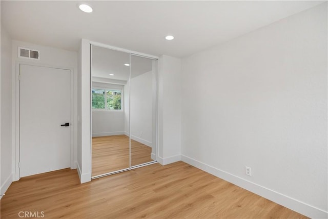 unfurnished bedroom featuring recessed lighting, a closet, visible vents, and light wood finished floors