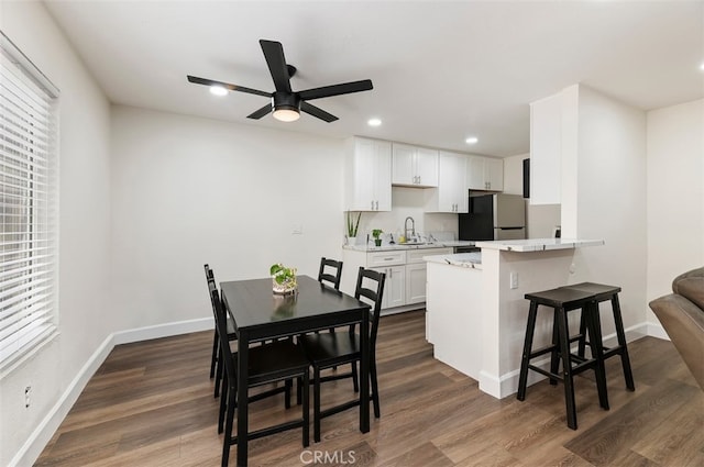 dining area with recessed lighting, dark wood finished floors, and baseboards