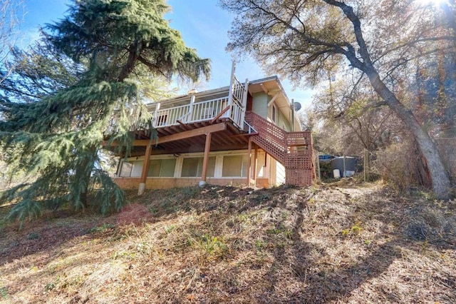 rear view of house featuring a deck and stairs