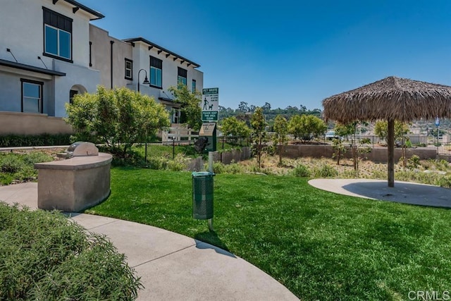 view of community featuring fence and a lawn