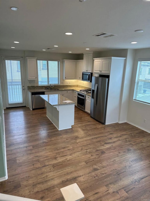 kitchen with dark wood finished floors, visible vents, appliances with stainless steel finishes, and a sink