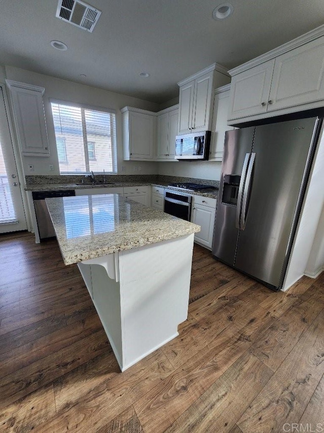 kitchen featuring dark wood finished floors, visible vents, appliances with stainless steel finishes, and a kitchen island