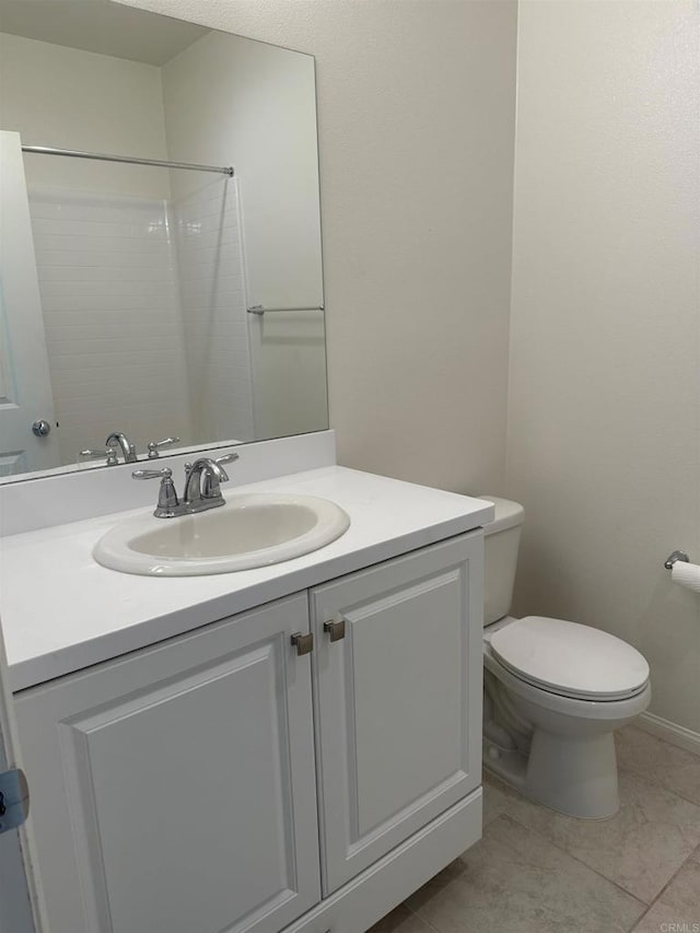 bathroom featuring toilet, tile patterned flooring, and vanity