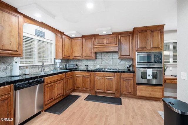 2438 Captains Walk, Bradley, CA 93426 - kitchen with stainless steel appliances, brown cabinets, light wood-style floors, tasteful backsplash, and healthy amount of natural light