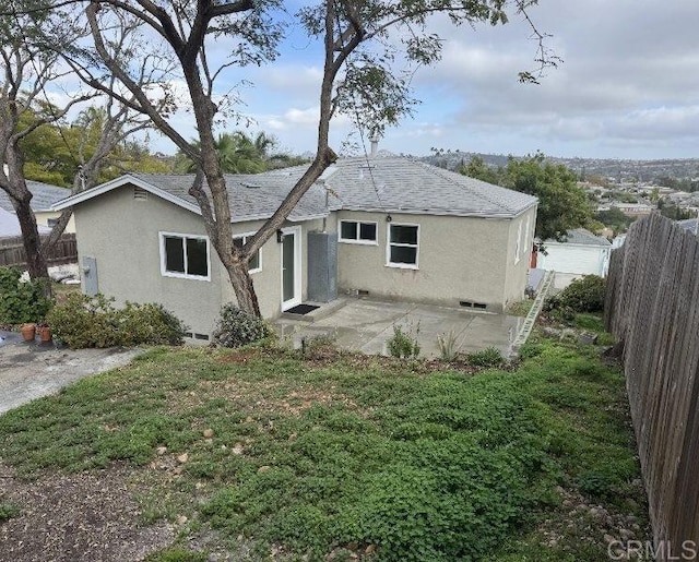 back of property with stucco siding, fence, a yard, and a patio area