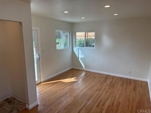 empty room with recessed lighting, baseboards, and wood finished floors