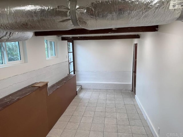 interior space featuring light tile patterned floors, baseboards, and a textured ceiling