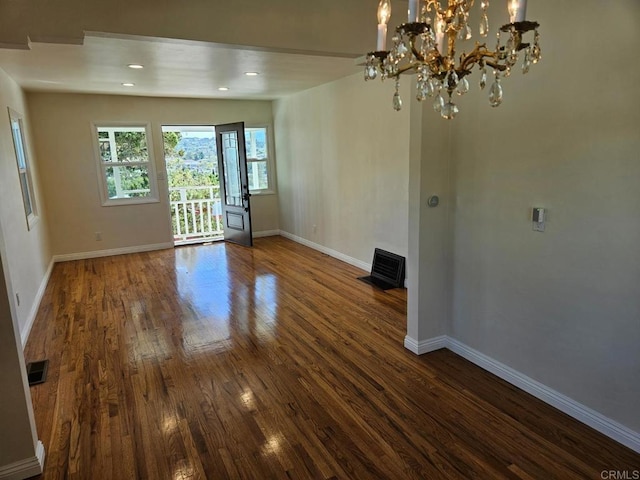 unfurnished dining area featuring dark wood finished floors, visible vents, and baseboards