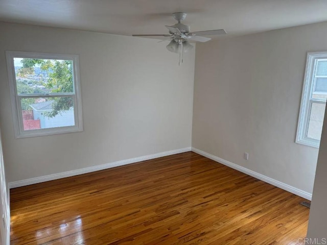 unfurnished room with ceiling fan, baseboards, and wood finished floors