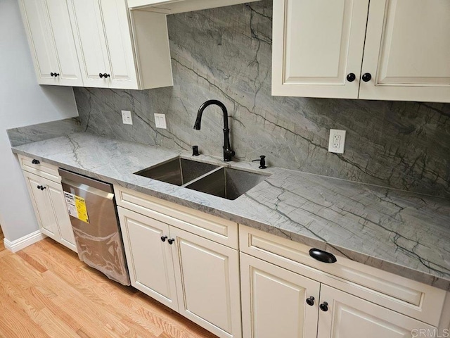 kitchen with light stone countertops, stainless steel dishwasher, light wood-type flooring, and a sink