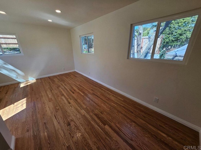 unfurnished room featuring dark wood-type flooring, recessed lighting, and baseboards